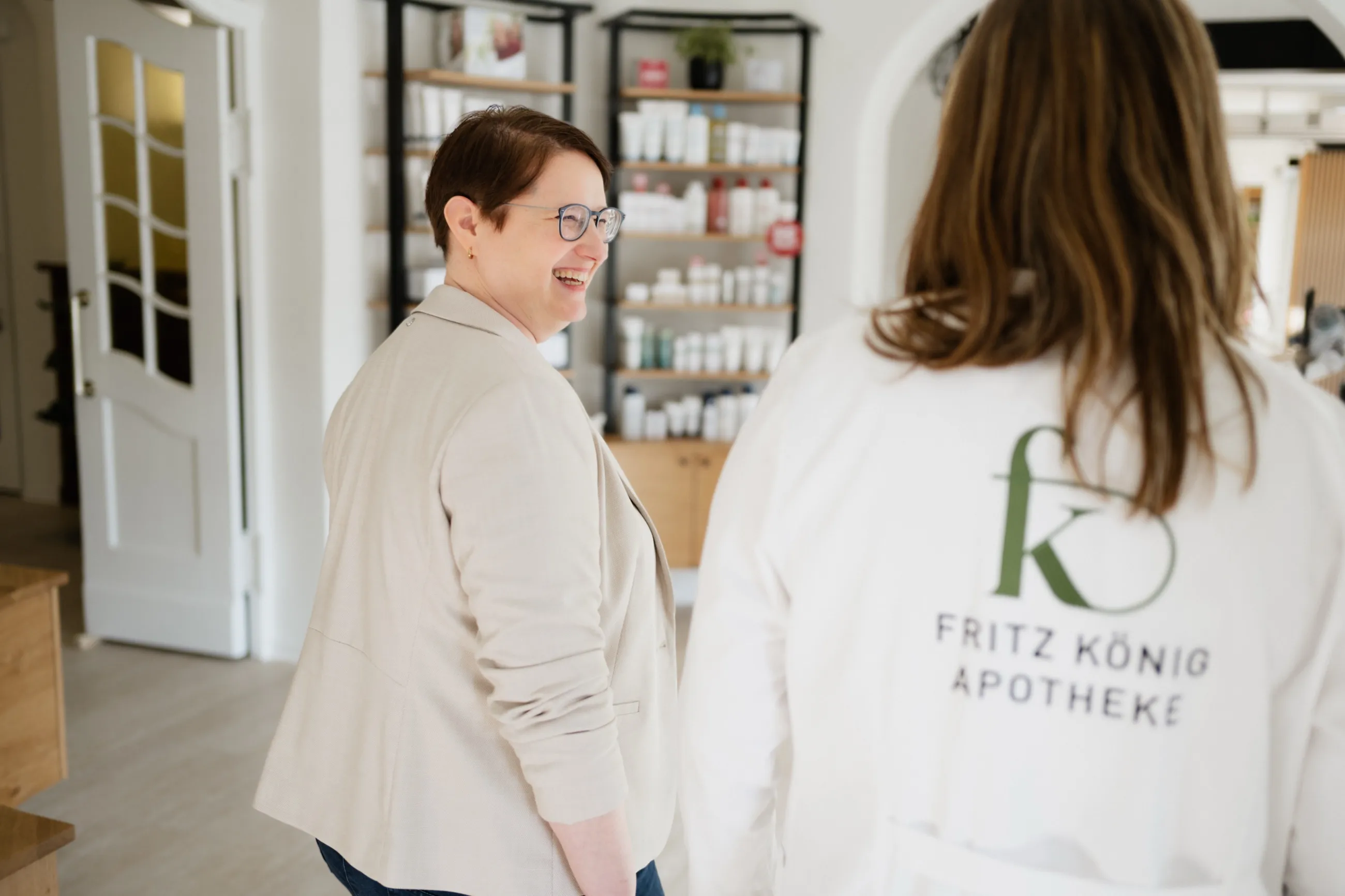 Dr. Ute Heeger lachend im Gespräch mit Theresa Fulst in der Fritz-König-Apotheke