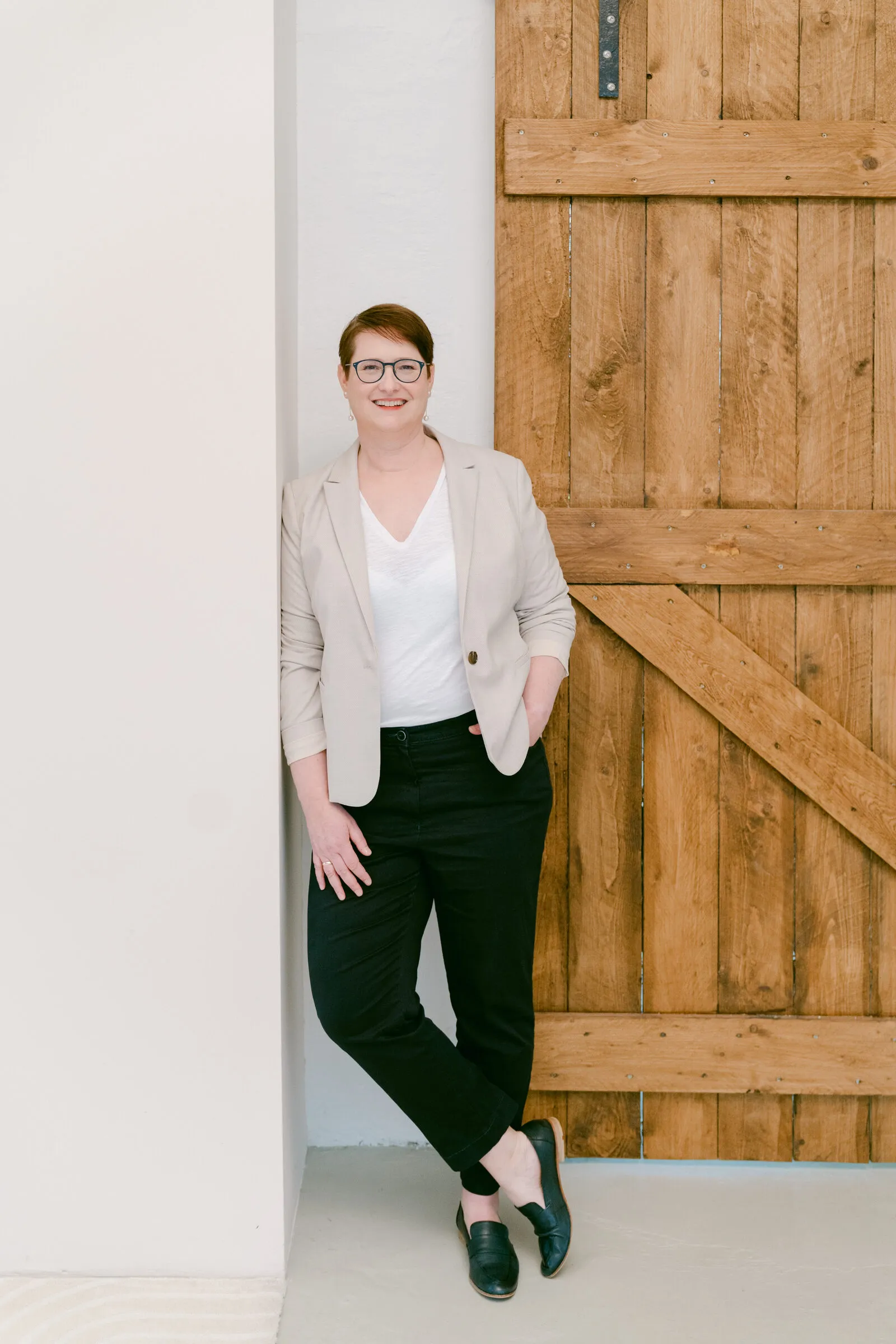 Dr. Ute Heeger lehnt entspannt an einem hölzernen Scheunentor